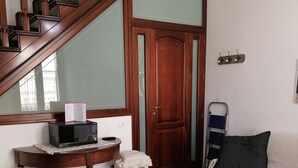 A room with a dining table, chairs, a sofa, a wooden staircase, a microwave, a small stool, and a cabinet. - near the sea and the center of San Vito Lo Capo is ideal for families (San Vito Lo Capo)