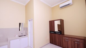 A bathroom with a white vanity, a mirror, and a wooden cabinet.
