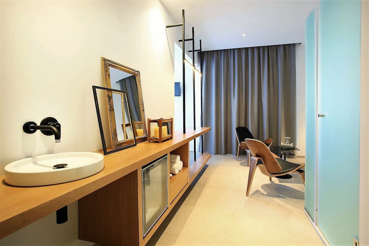 A modern bathroom with a sink, mirrors, and a shower.