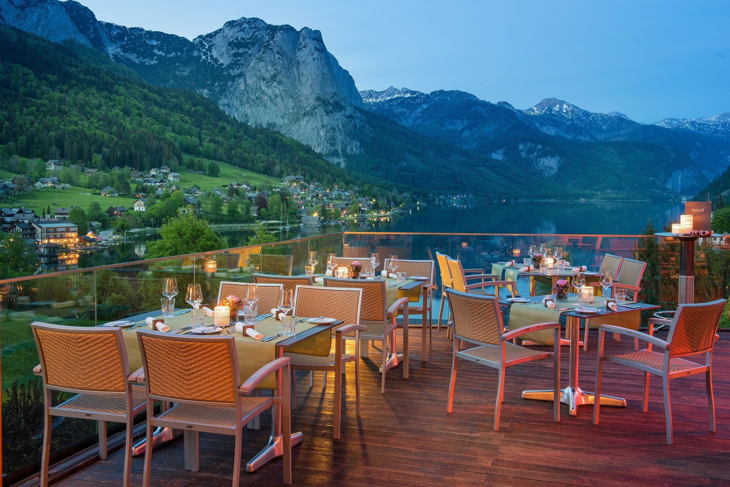 Un restaurant doté d’une terrasse offrant une vue sur un paysage montagneux et un lac.