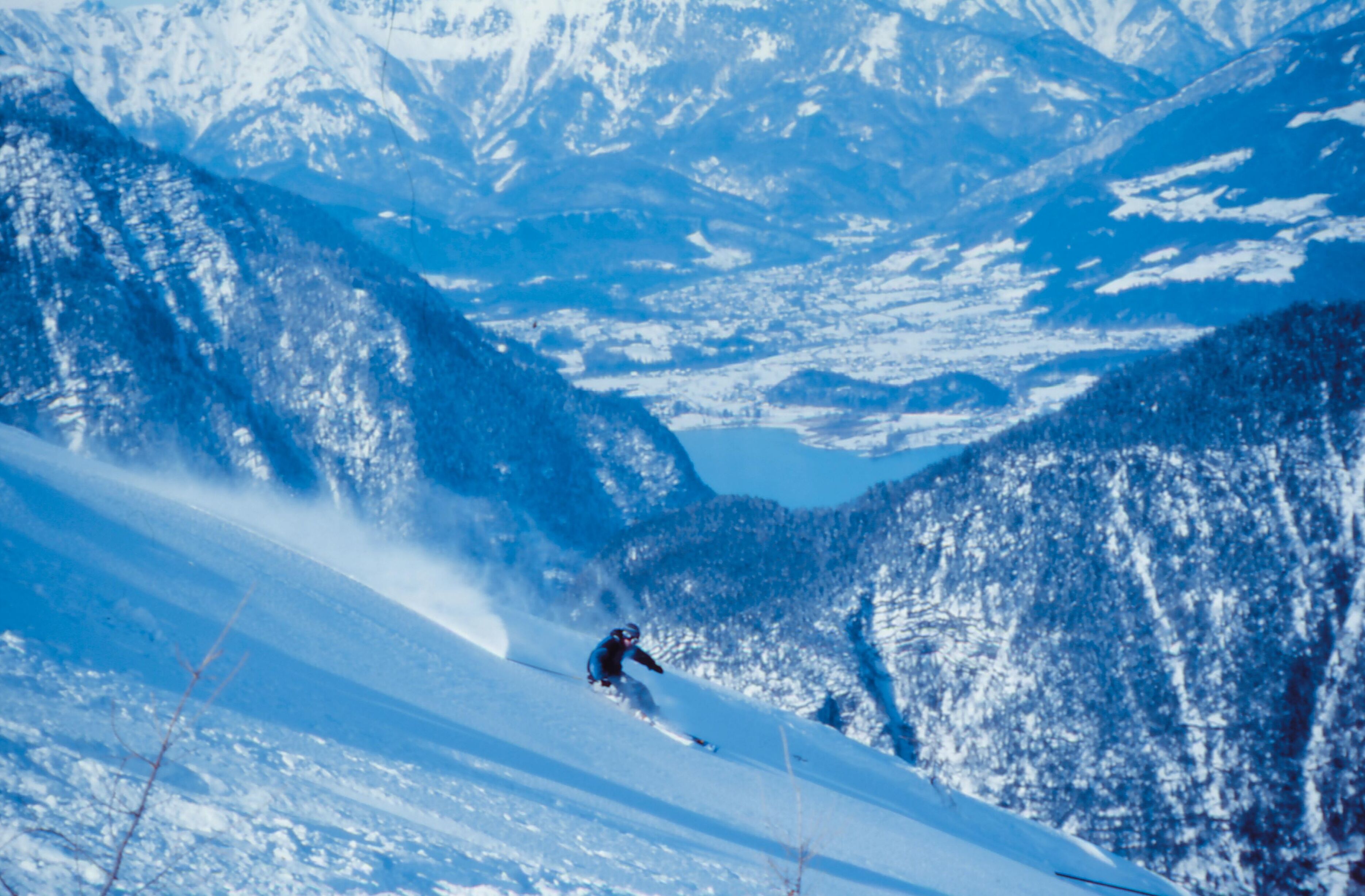 Un paysage de montagne enneigé avec un skieur.
