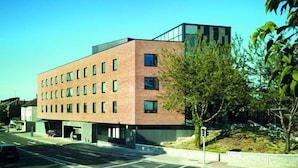 A modern multi-story building with a brick facade and large windows. - Yugo Explore - Broadstone Hall (Dublin)