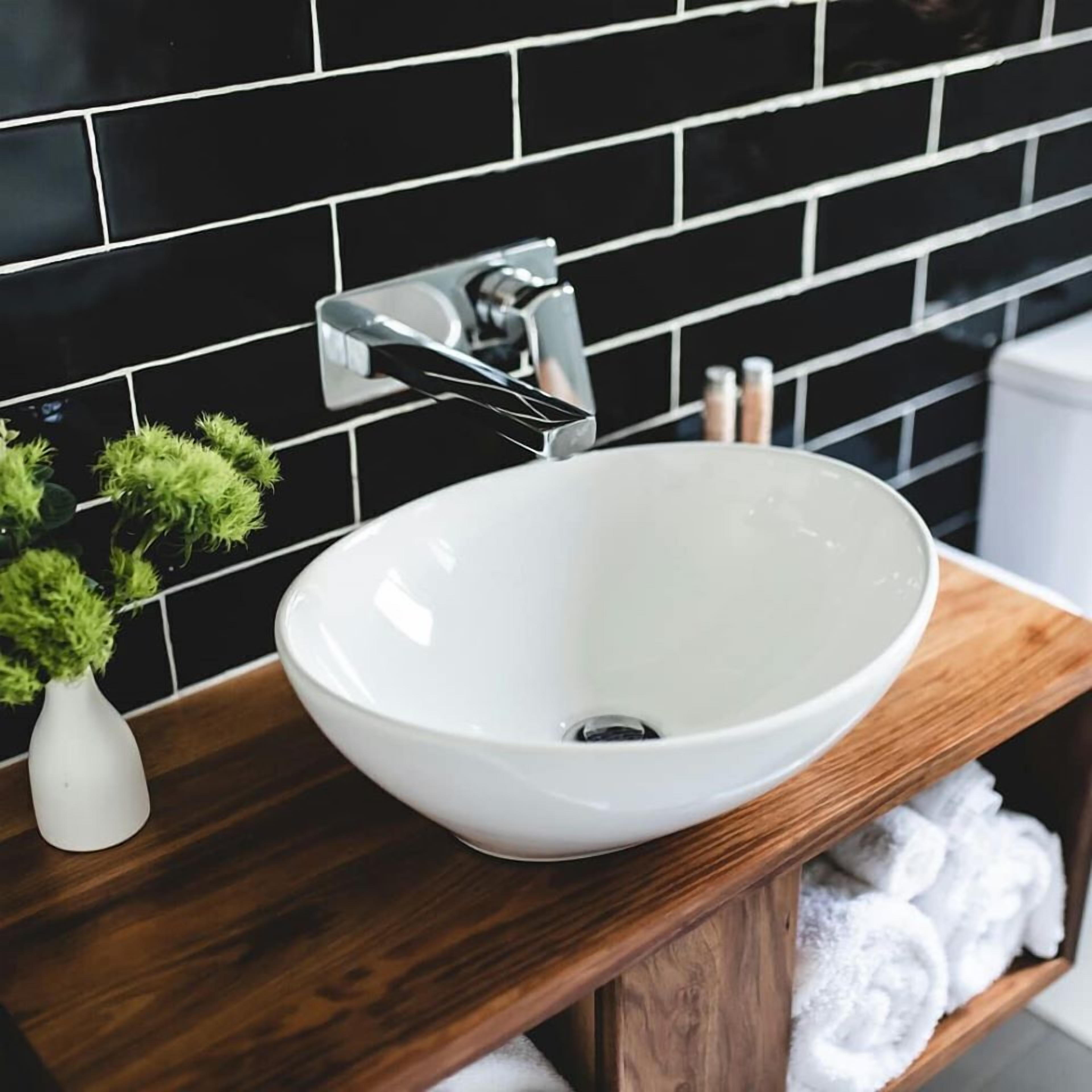 A white ceramic sink with a modern faucet on a wooden countertop.