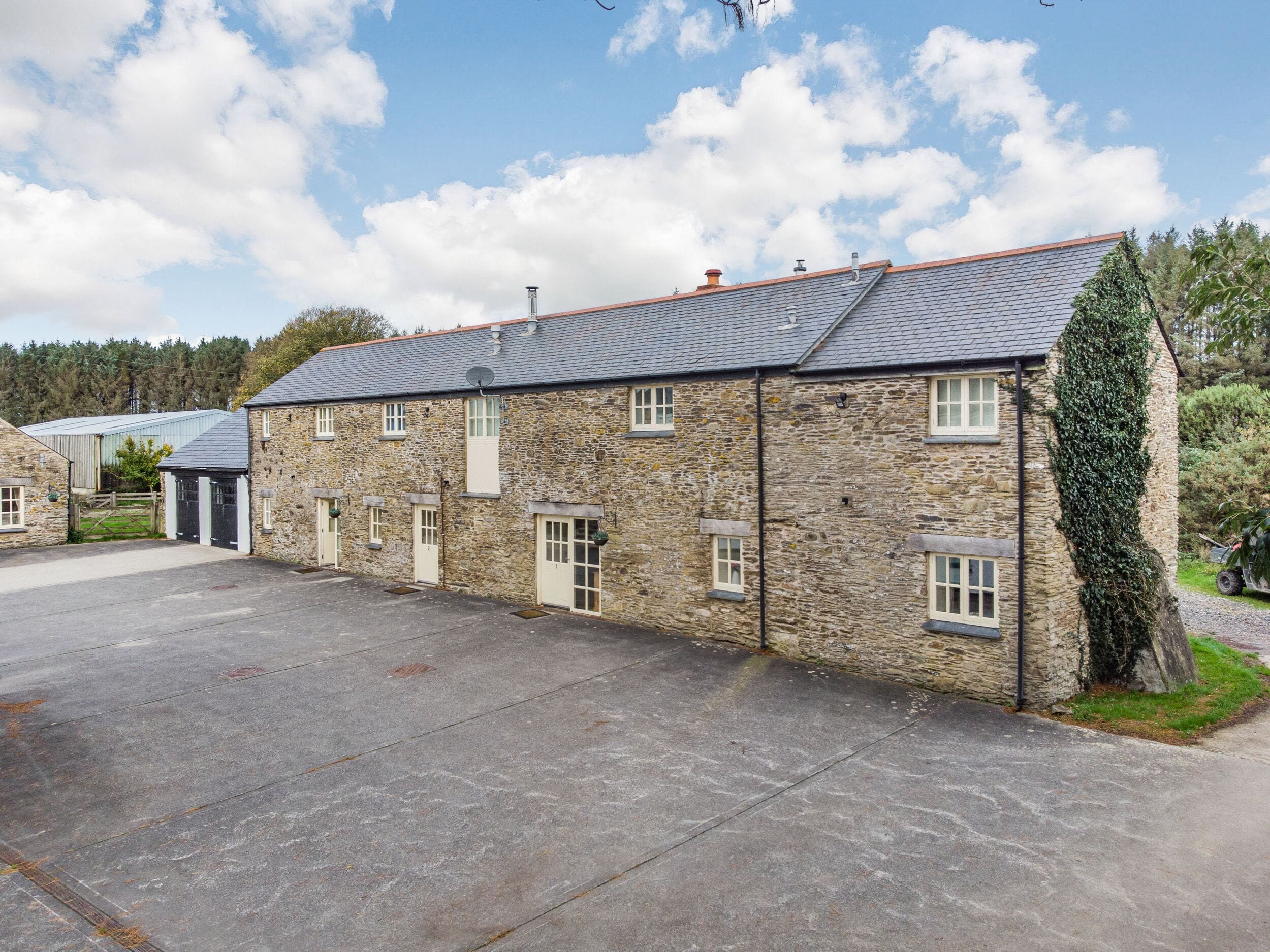 A stone building with a flat roof and multiple windows.