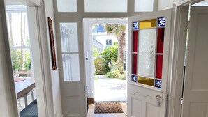 A hallway with a white door leading to a garden. - Porth House with south facing courtyard garden! (St Ives)