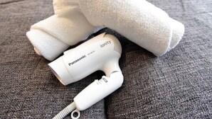 Un sèche-cheveux ionique Panasonic posé sur une surface grise texturée.