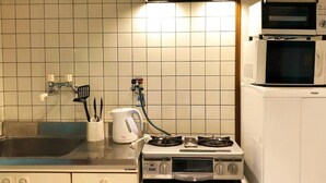 Cocina pequeña con fregadero, estufa y microondas.