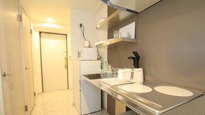 A compact kitchen with a refrigerator, microwave, and a sink with a dish rack. - Prosper Rainbow Villa (Osaka)