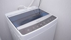 Una lavadora Haier blanca con pantalla digital y panel de control.