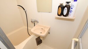 Ein Badezimmer mit Badewanne, Waschbecken und Ablage für Toilettenartikel.