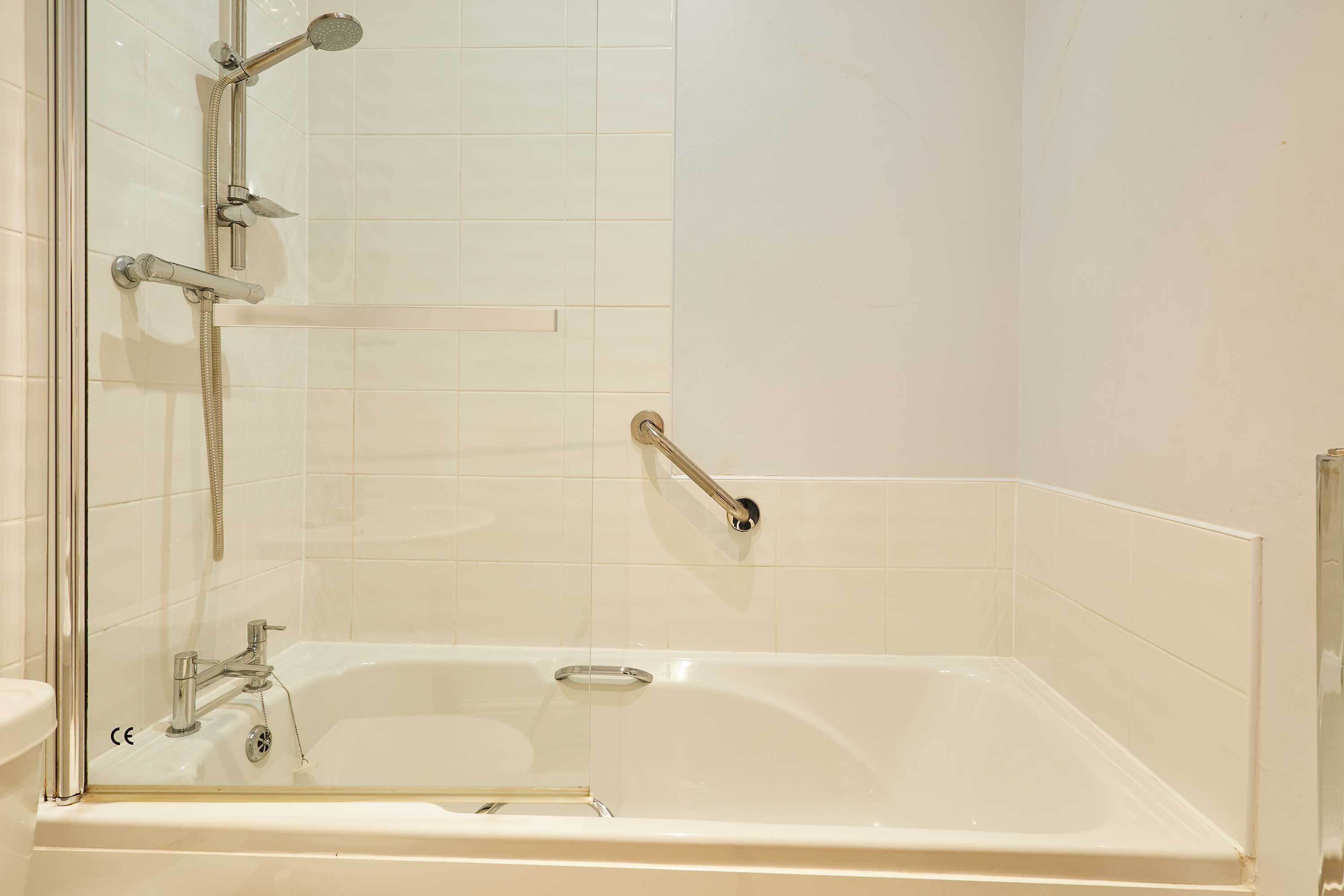 Un baño con bañera, ducha y cabina de ducha con mampara de vidrio.