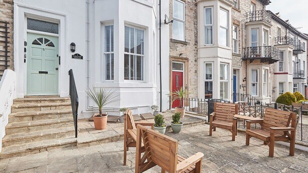 A terrace with wooden furniture and potted plants. - Host & Stay | The Normanby (Whitby)