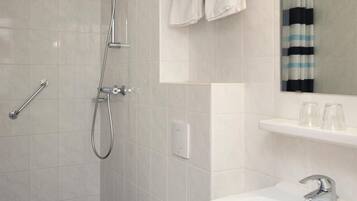 A modern bathroom with a shower, toilet, and sink.