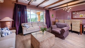 A cozy living room with a sofa, armchairs, a coffee table, and a dining area with wicker chairs. - Spacious  holiday house - pool / jacuzzi / sauna / playground / 8+2 (Rakalj)