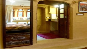 Una habitación con cama, espejo, baño y una ventana pequeña.