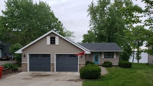 A two-story house with a garage, a blue front door, and a small porch. - Lakeside Leisure: Relax, Recharge, Reconnect! (Alexandria)