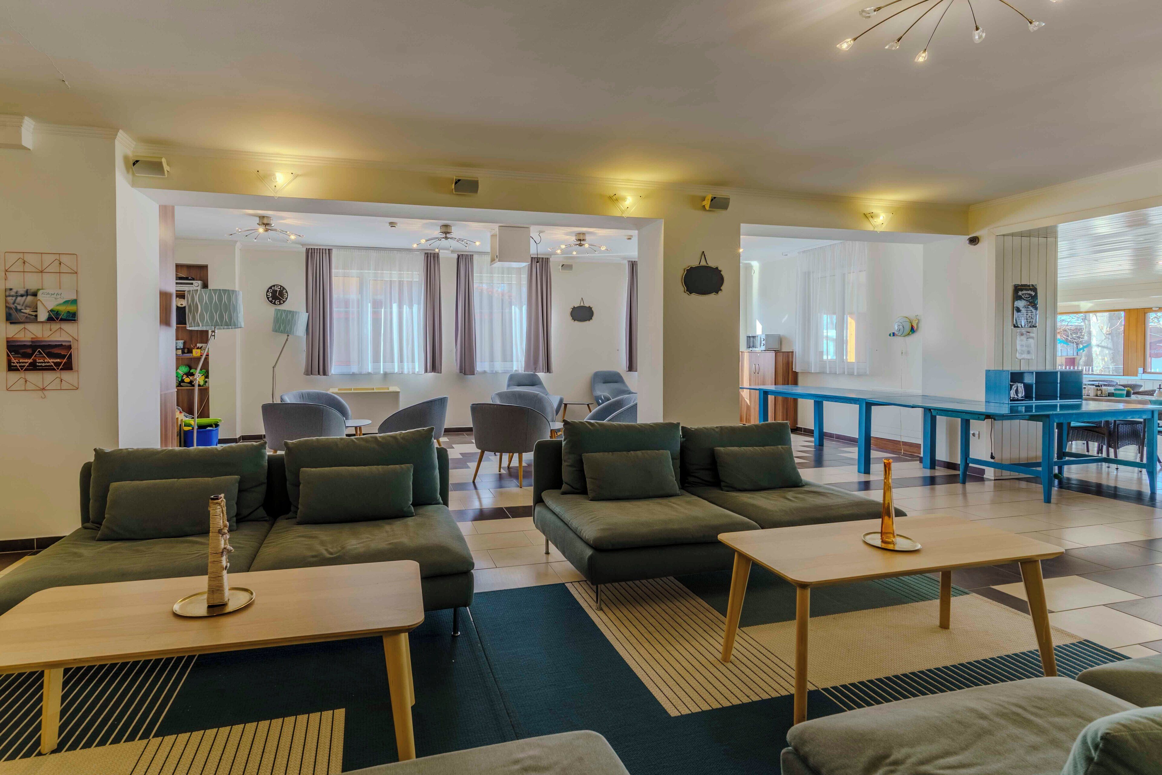 Una sala de estar moderna con sofás, una mesa de centro y un comedor con una mesa y sillas azules.