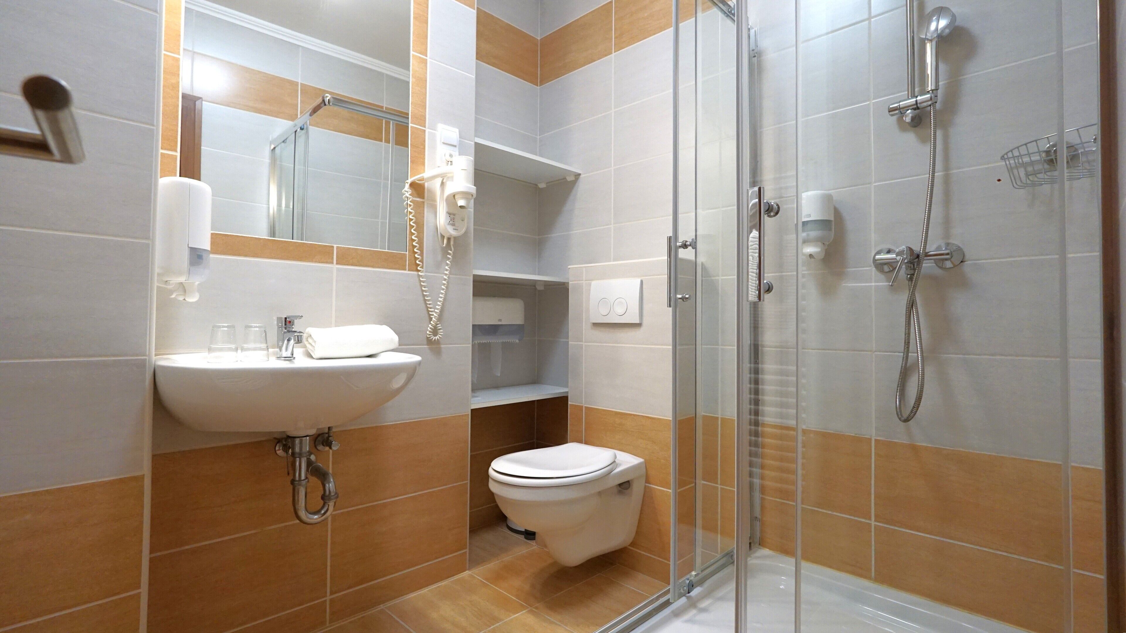 A modern bathroom with a sink, toilet, and shower.