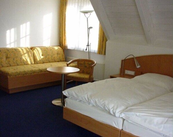 A hotel room with a bed, a sofa, a chair, and a small table. - Landgasthof Hirsch (Remshalden)