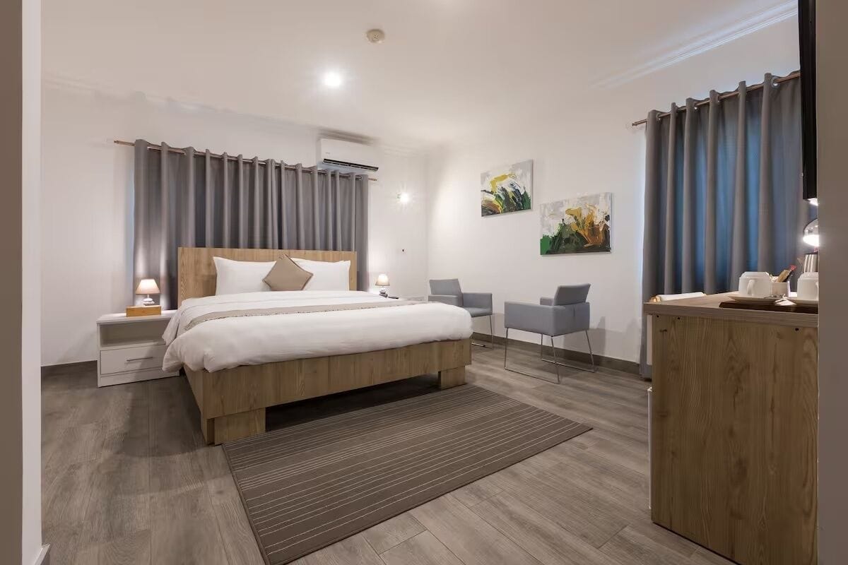 Ein modernes Hotelzimmer mit einem hölzernen Bett, einem Schreibtisch und einem Stuhl.