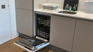 A compact kitchen with a built-in dishwasher, a sink, and a small countertop.