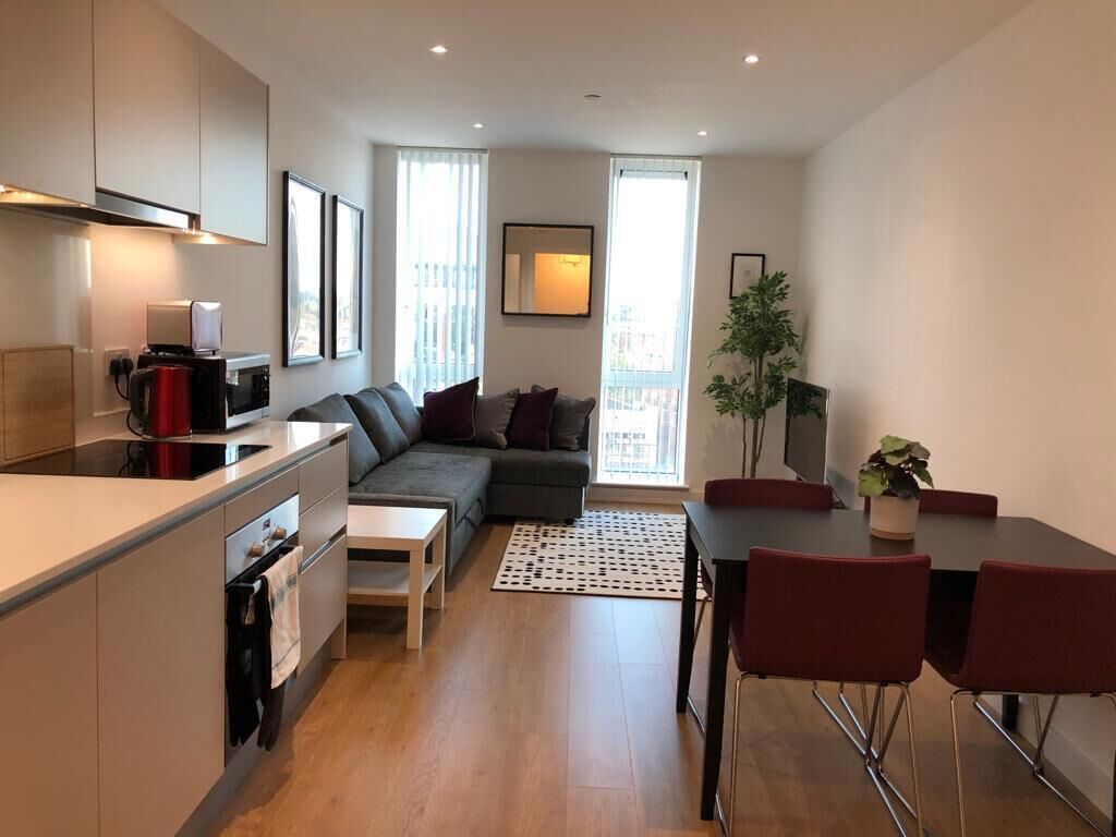 A modern apartment with a kitchen, dining area, and living room.