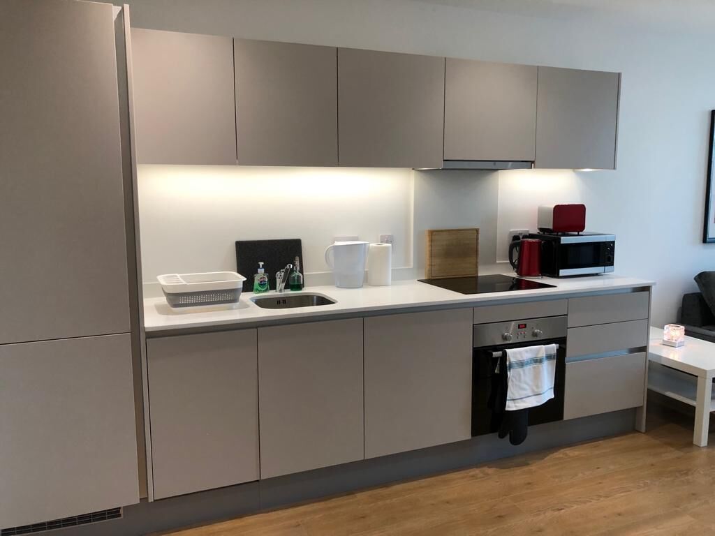 A modern kitchen with a built-in oven, a microwave, and a sink.