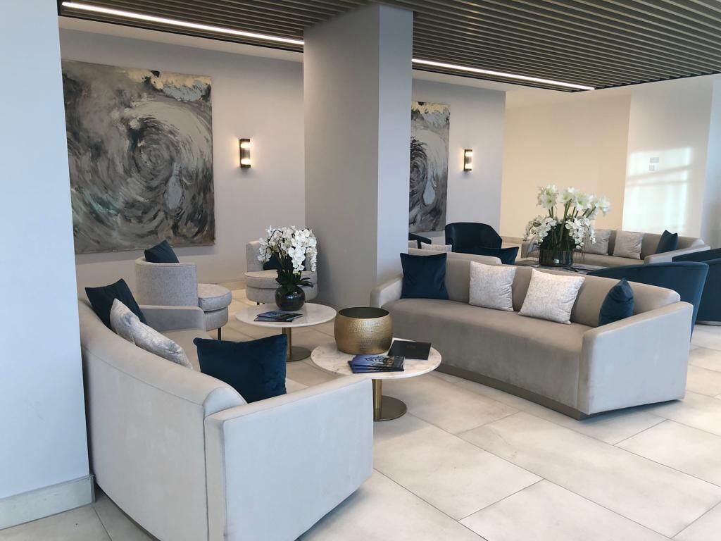 Un espace de détente moderne avec des canapés, une table basse et des plantes décoratives.