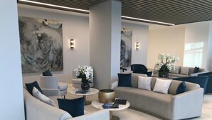 A modern lounge area with sofas, a coffee table, and decorative plants.