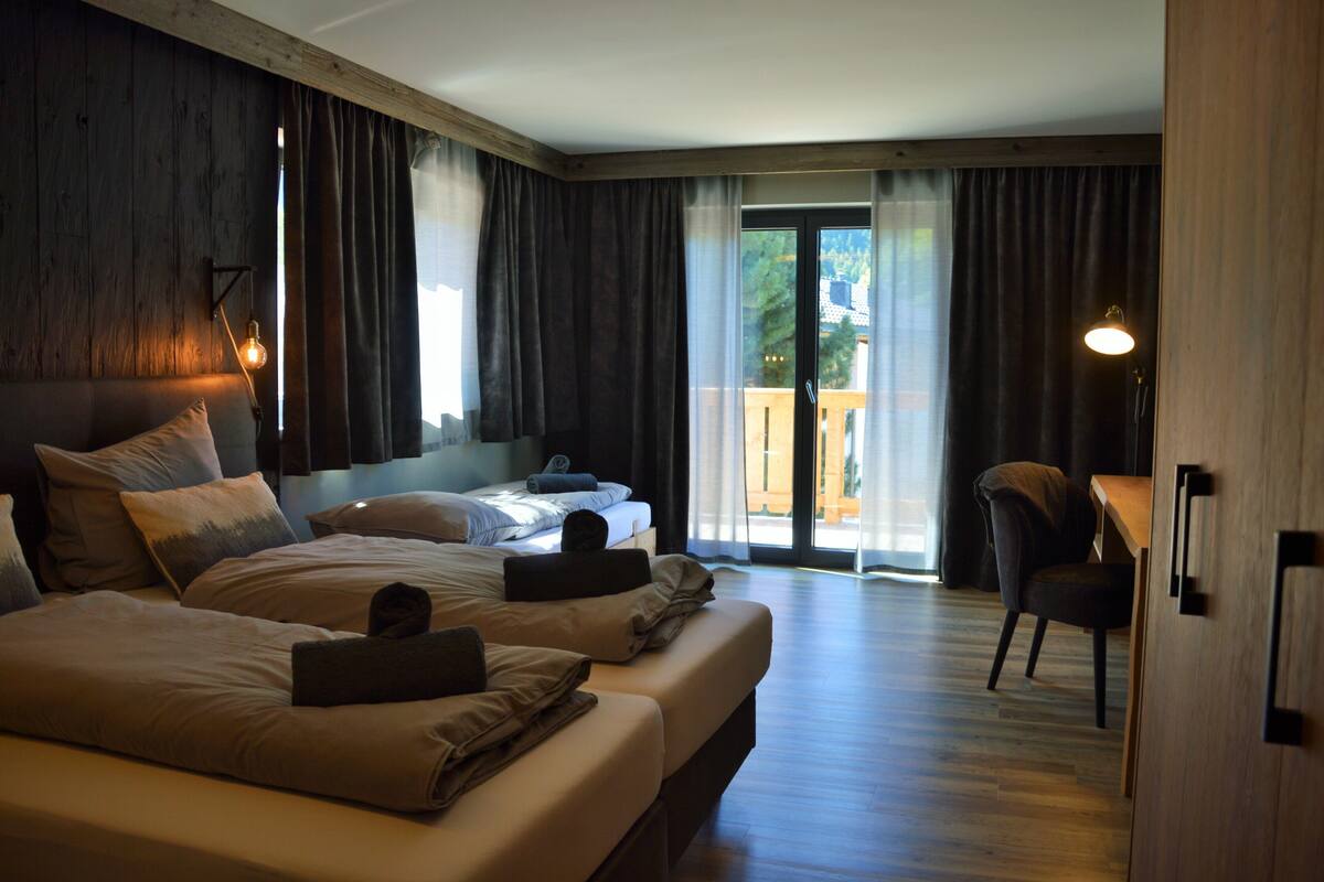 Ein Hotelzimmer mit zwei Betten, einem Schreibtisch und einem Sessel.