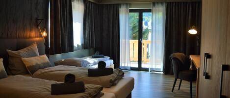 Habitación de hotel con dos camas, un escritorio y una silla.