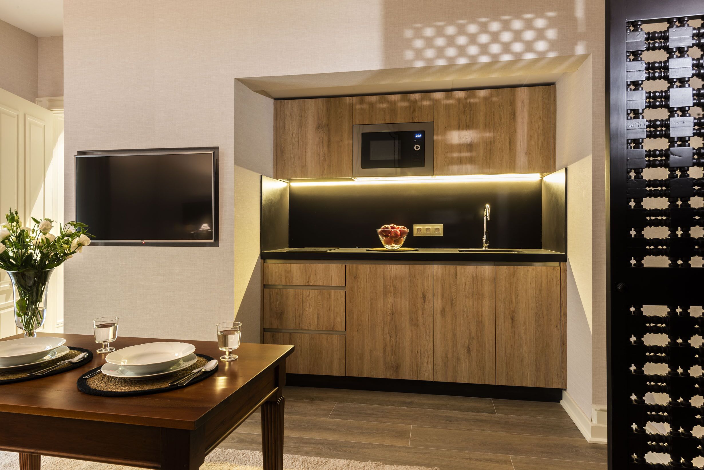 A modern kitchen with wooden cabinets, a built-in microwave, and a stainless steel sink.