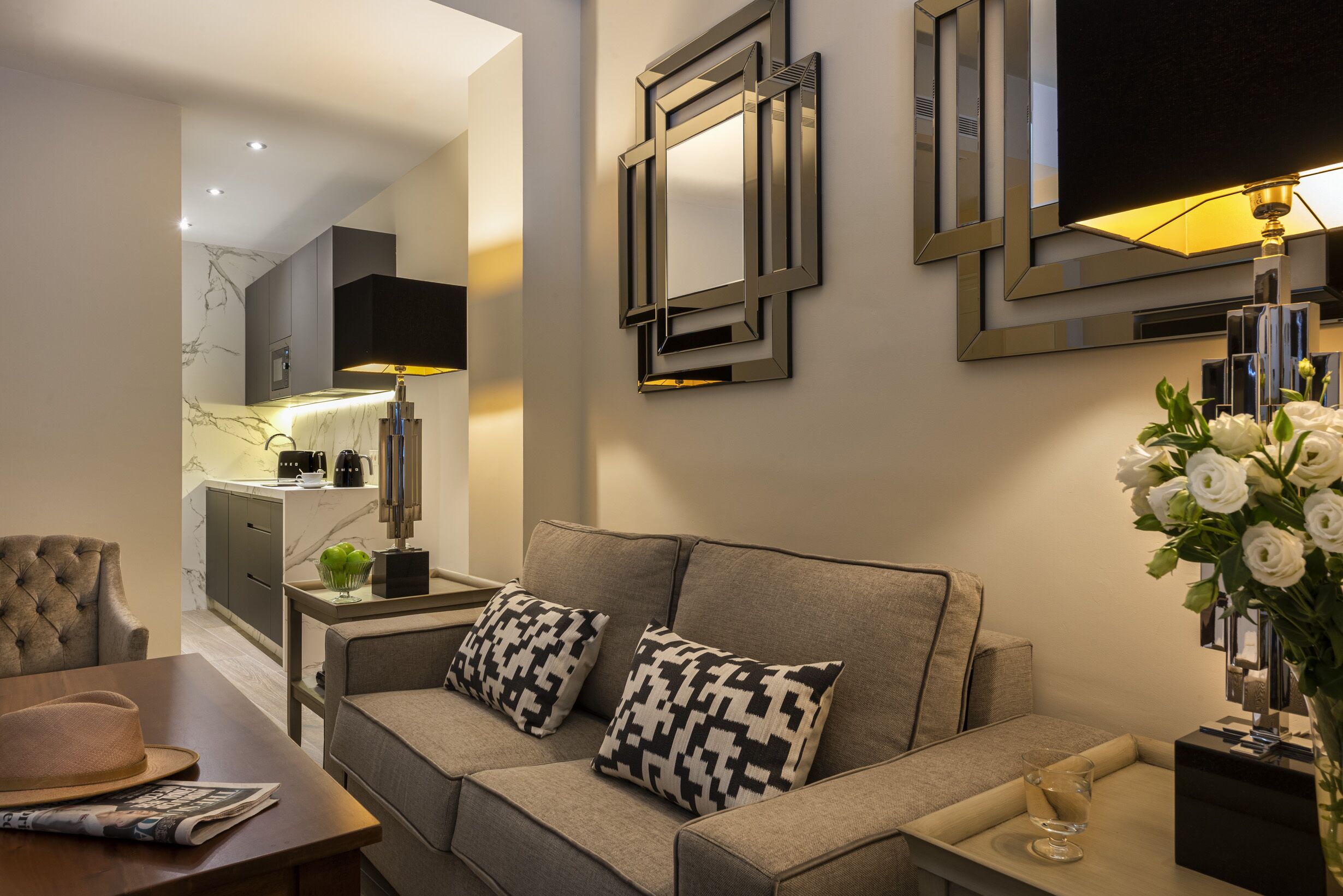 Una sala de estar moderna con un sofá, una mesa de centro y un televisor montado en la pared.