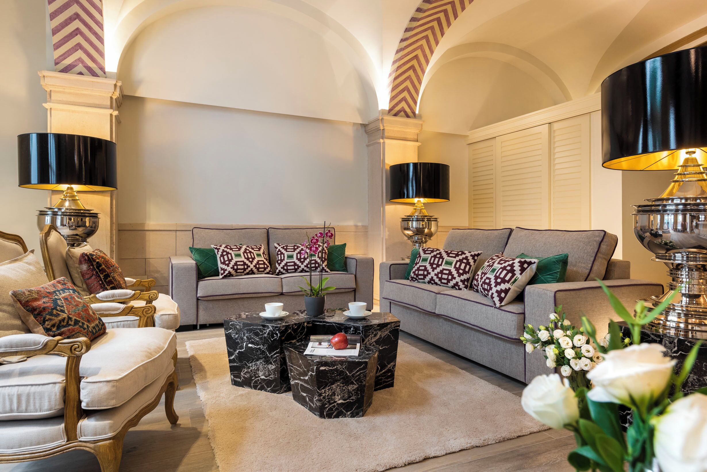 A living room with two sofas, a coffee table, and decorative lamps.