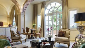 Un salón amplio con techos altos, ventanas grandes y muebles elegantes.