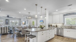 A spacious kitchen with white cabinets, a granite island, and pendant lighting. - Gulf Views with Pool and Sun Deck Space (Destin)
