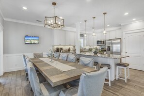 A modern kitchen with white cabinets, stainless steel appliances, and a granite countertop.