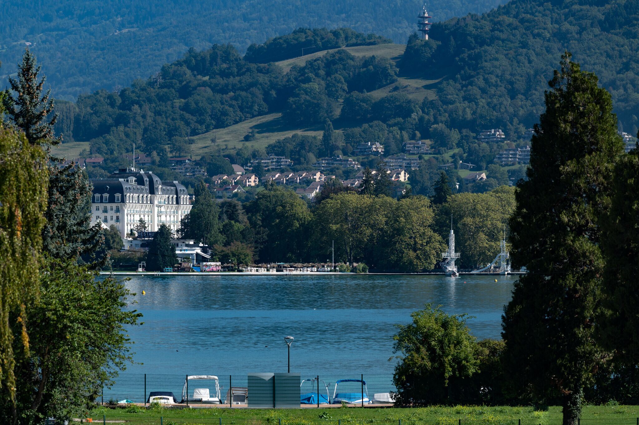 A lakeside view with a large building, possibly a hotel, in the background.
