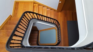 A modern staircase with wooden steps and a black handrail. - Cool Guesthouse (Porto)