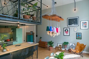 A modern kitchen with a wooden countertop, a built-in stove, and a hanging light fixture.