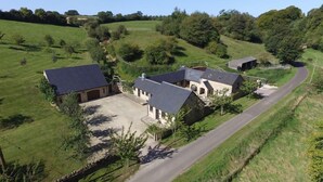 A rural property with multiple buildings, including a main house with a large driveway and several smaller structures. - The Cotswold Manor Wychwood, with Hot-Tub, Games Barn, 3 acres of Parkland (Witney)