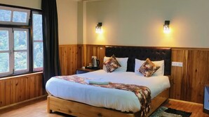 A bedroom with a wooden bed, two bedside tables, a nightstand, a window with curtains, and a wall-mounted light fixture. - Rufina Lachen Deezong (Chungthang)