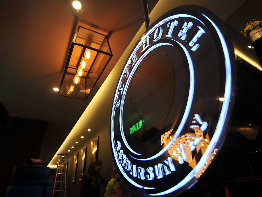 Um letreiro de neon com o texto 'HOTEL' e 'SHILTON' em um design circular.