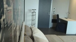 A modern bedroom with a bed, a desk, and a chair. - B&B Villa Antilia (Busca)