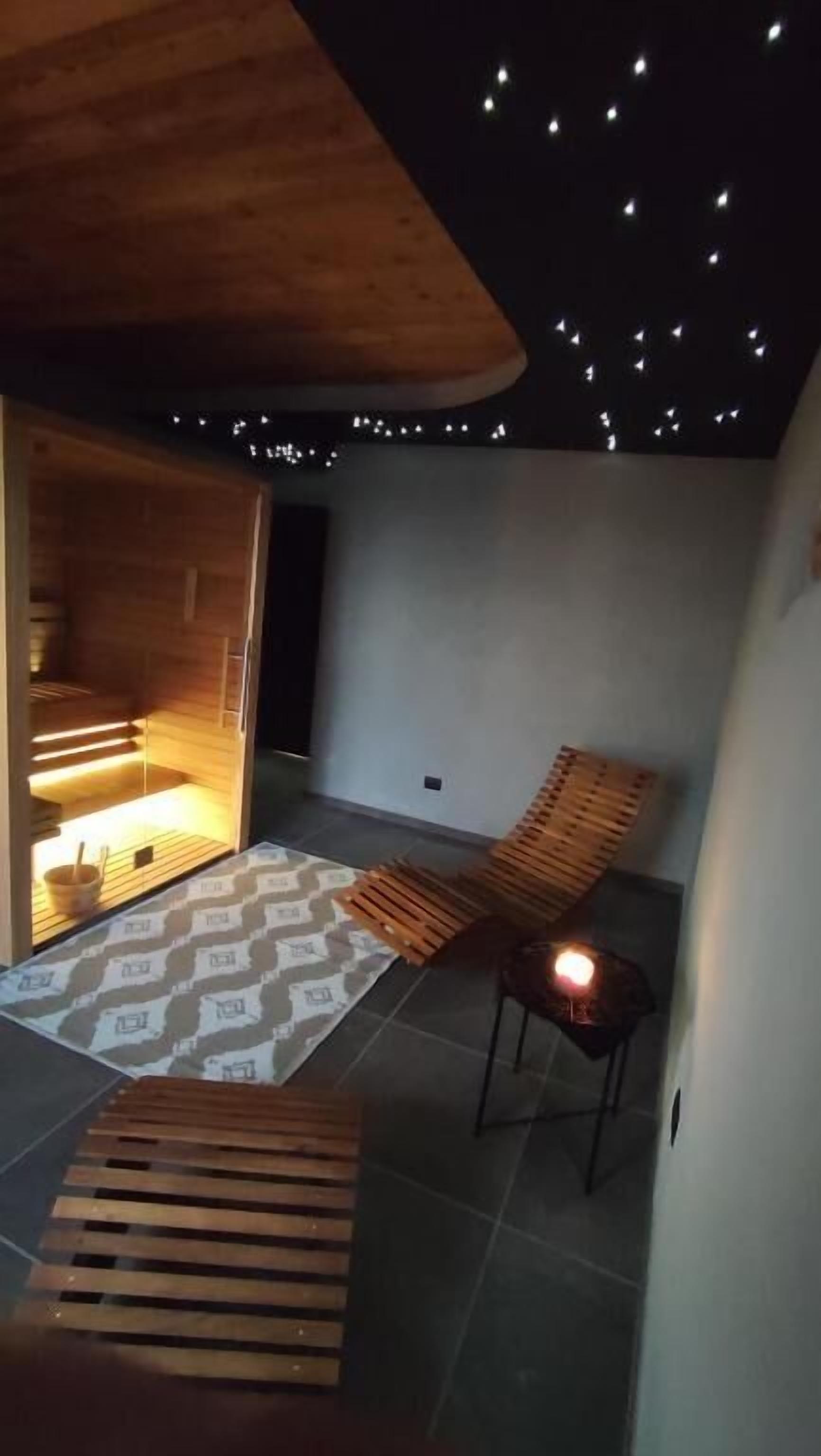 Un interior moderno con techo de madera, alfombra estampada y un rincón de descanso con bancos.