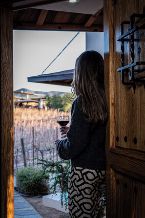 A person standing at a doorway, holding a wine glass. - Ojo Azul Resort (Valle de Guadalupe)