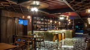 Una zona de bar con mobiliario de madera y suelo a cuadros.