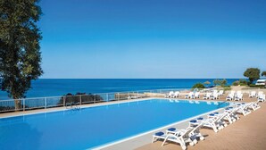 A swimming pool with lounge chairs and a view of the ocean. - Victoria Mobilehome Solaris fkk Resort (Tar-Vabriga)