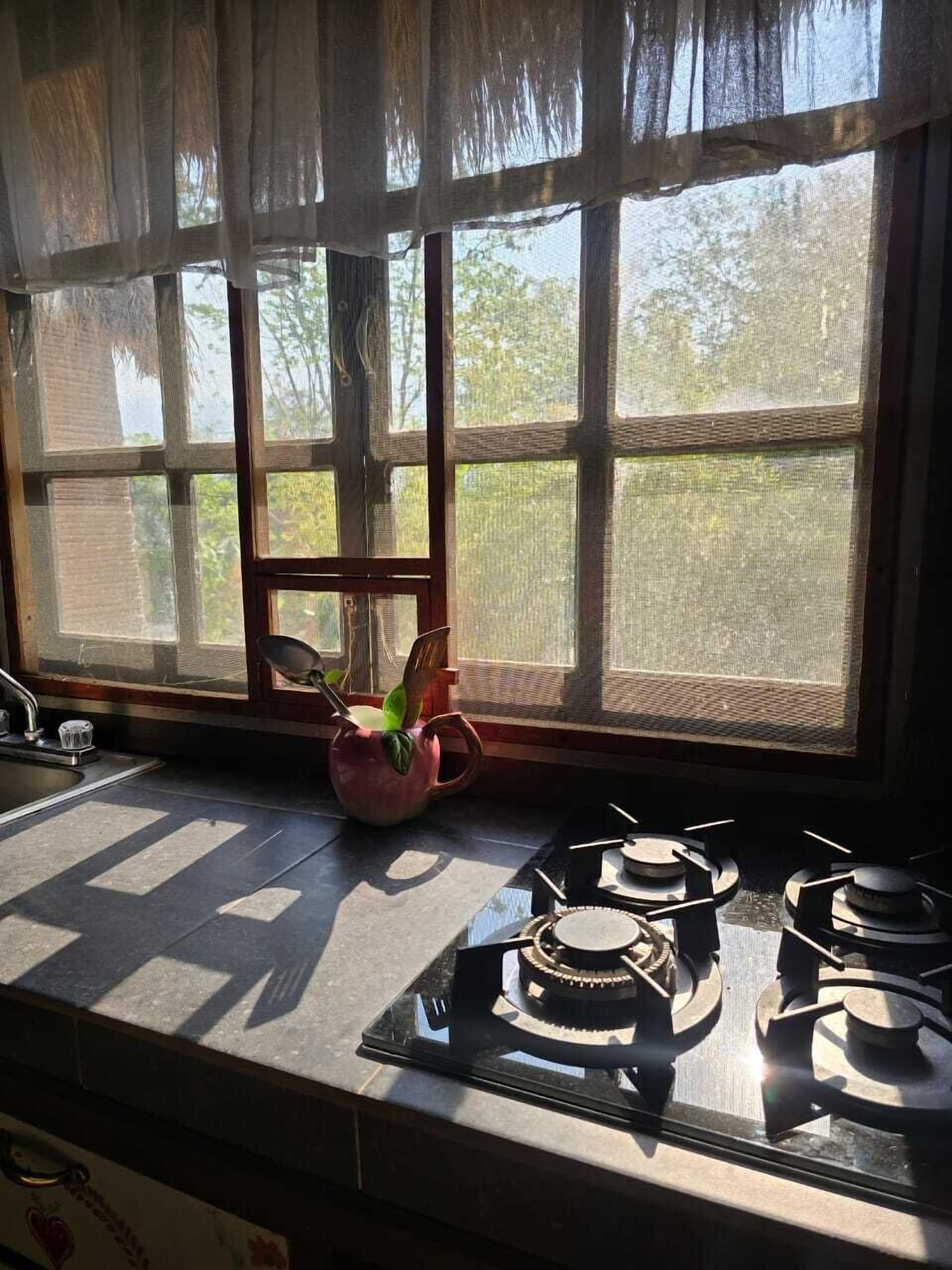 Eine Küche mit Fenster, Spüle und Herd.
