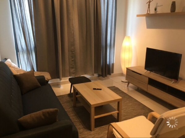 Relax in this stylish living room with a sofa, coffee table, and flat-screen TV.